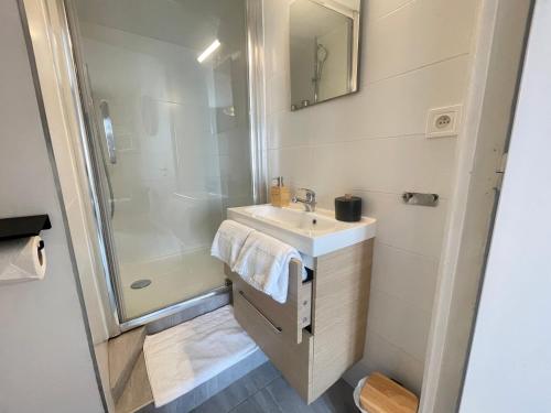 uma casa de banho com um lavatório e um chuveiro em Au Coin de YourHostHelper em Reims