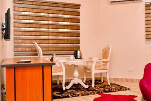 um quarto com uma mesa e cadeiras e um telefone em Alim Royal Hotel em Jahi