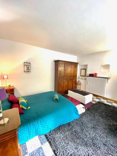 une chambre avec un grand lit avec une couverture bleue dans l'établissement Appartement Haut de Villa centre-ville CORTE, à Corte