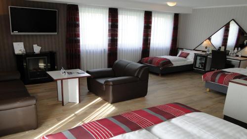 a hotel room with a couch chair and a living room at Motel RL in Oberthulba