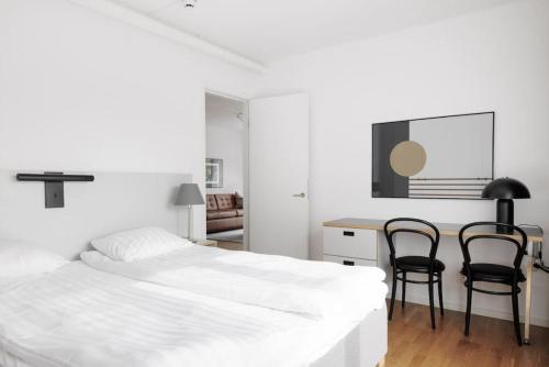 a bedroom with two beds and a desk and chairs at Contemporary 2-BR with Workspace in Kottla