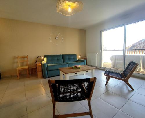 un salon avec un canapé et une table dans l'établissement L'Avocette plage, au coeur de Saint Brévin l'Océan, à Saint-Brévin-les-Pins