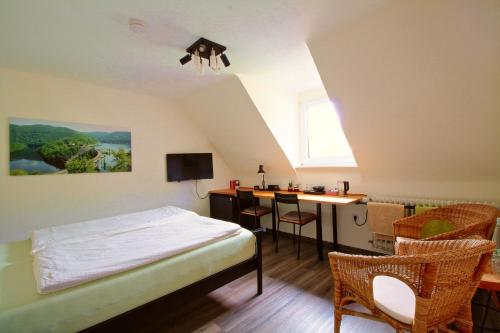 a bedroom with a bed and a desk in a room at Toms Gästehaus in Schleiden