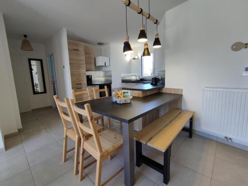 une cuisine et une salle à manger avec une table et des chaises dans l'établissement L'Avocette plage, au coeur de Saint Brévin l'Océan, à Saint-Brévin-les-Pins