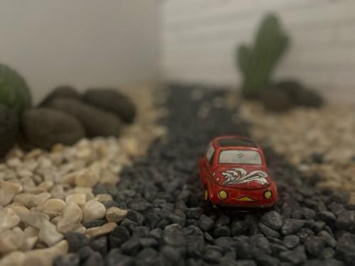 a small red toy car on a gravel road at Cinquecento B&B in Barcellona-Pozzo di Gotto