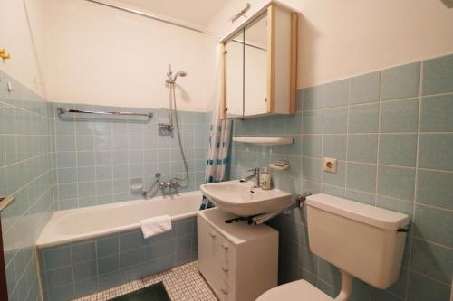 a bathroom with a sink and a toilet and a tub at Apartment "Schlupfwinkel" im Haus Feldbergblick, Lenzkirch, Innenpool, Sauna in Lenzkirch
