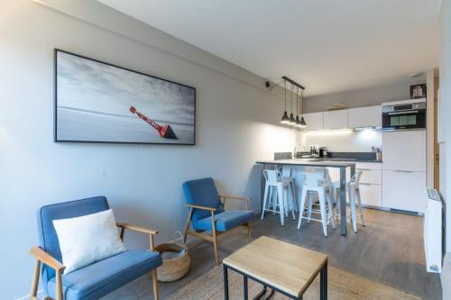 Il comprend un salon et une cuisine avec une table et des chaises. dans l'établissement Beautiful flat with swimming pool tennis court and private car parking 64, à Le Touquet-Paris-Plage