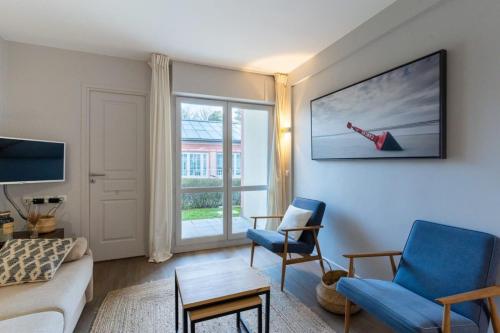 un salon avec un canapé et une fenêtre dans l'établissement Beautiful flat with swimming pool tennis court and private car parking 64, à Le Touquet-Paris-Plage