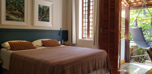 a bedroom with a bed and a large window at Pousada Tekoá Indiana in Cachoeiras de Macacu