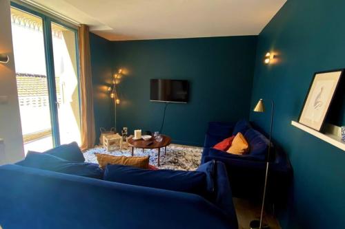 un salon bleu avec un canapé bleu et une table dans l'établissement Cosy flat close to the sea with large terrace, à Le Touquet-Paris-Plage