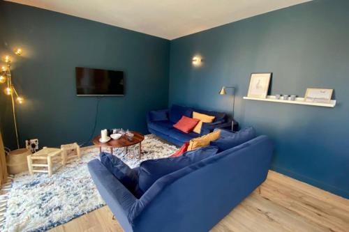 salon z niebieskimi ścianami i niebieską kanapą w obiekcie Cosy flat close to the sea with large terrace w mieście Le Touquet-Paris-Plage