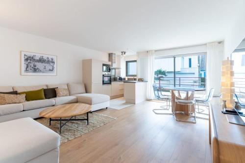 un soggiorno con divano e tavolo di Magnificent town-centre apartment with two terraces 5 people a Le Touquet-Paris-Plage