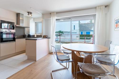 cocina y comedor con mesa y sillas en Magnificent town-centre apartment with two terraces 5 people, en Le Touquet-Paris-Plage