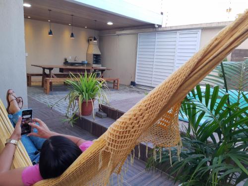 een vrouw in een hangmat die een foto neemt van een patio bij CASA COM PISCINA GARANHUNS in Garanhuns