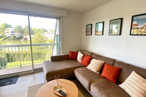 un salon avec un canapé et une grande fenêtre dans l'établissement Superb duplex with lake view for 6 people, à Le Touquet-Paris-Plage