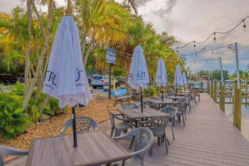 a row of tables and chairs with umbrellas at Heated Pool, Strong WI-FI, TV, Tiki Bar & Grill! in Sarasota