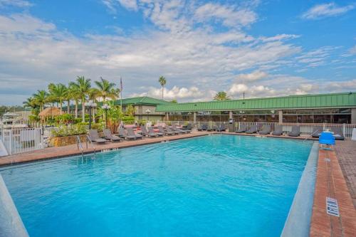 a large swimming pool with chairs and a building at Heated Pool, Strong WI-FI, TV, Tiki Bar & Grill! in Sarasota