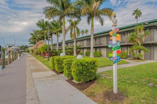 a street sign in front of a building with palm trees at Heated Pool, Strong WI-FI, TV, Tiki Bar & Grill! in Sarasota