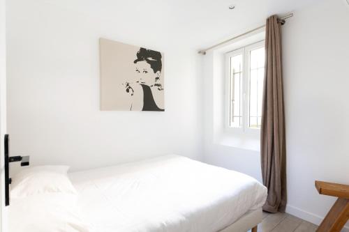 une chambre blanche avec un lit et une fenêtre dans l'établissement Central Apartment in the heart of the Marais With Air Conditioning, à Paris