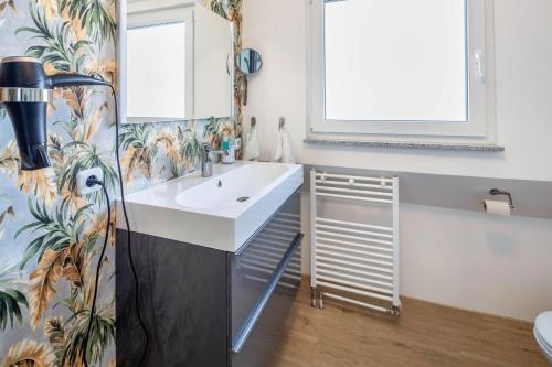 ein Bad mit einem Waschbecken und einem Spiegel in der Unterkunft Hue Space Air in Kassel