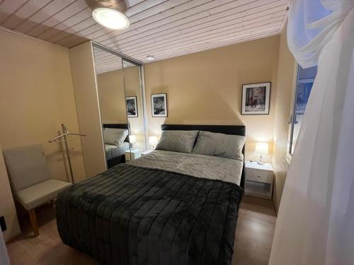 sypialnia z łóżkiem i krzesłem w obiekcie Villa IRIS 4, Himos w mieście Jämsä