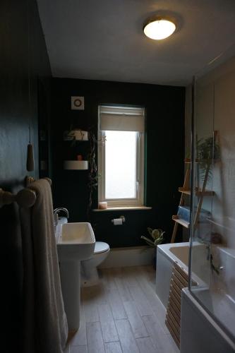 a bathroom with a sink and a toilet and a window at Ben & Maria's Guesthouse in Bath