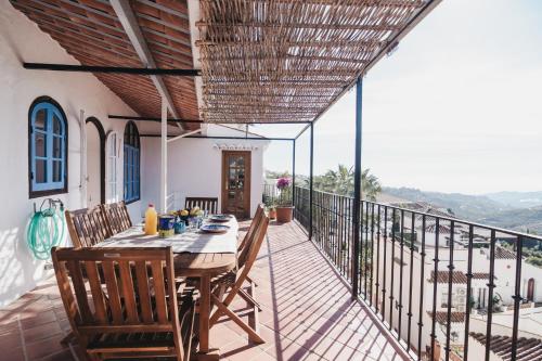 a patio with a table and chairs on a balcony at Casa La Martina Frigiliana in Frigiliana