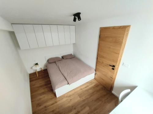 een kleine slaapkamer met een bed en een houten vloer bij Casa Gray 2 in Koper