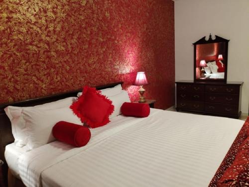 a bedroom with a bed with red pillows on it at فندق روتانة الفرسان بالحمرا in Jeddah