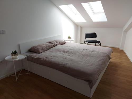 een slaapkamer met een bed en een stoel en een dakraam bij Casa Gray 2 in Koper