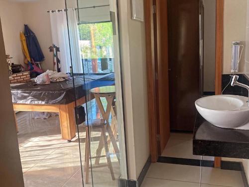 a bathroom with a glass table and a sink at Sítio Maravilhoso a 40min de BH! in Lagoa Santa