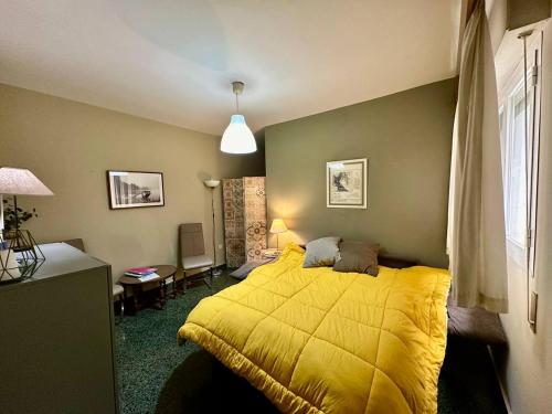 a bedroom with a yellow bed in a room at Apartamento Royal Centro de Ronda in Ronda