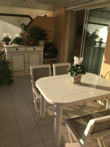 uma mesa branca e cadeiras num quarto em Water front one bed room apartment for beach lovers em Saint-Laurent-du-Var