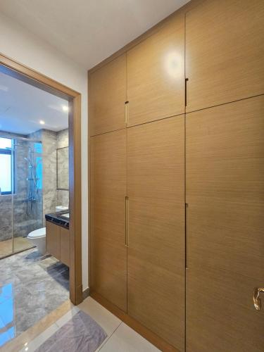 a bathroom with wooden cabinets and a shower at R&F Princess Cove JB Apartment Suites By SC Homestay in Johor Bahru