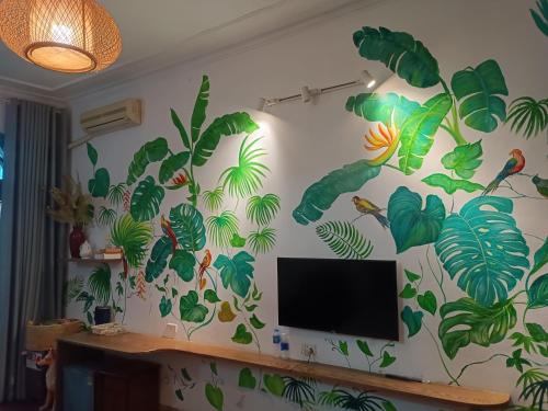 een muur met een muurschildering van tropische planten bij Nemohousehomestay in Hanoi
