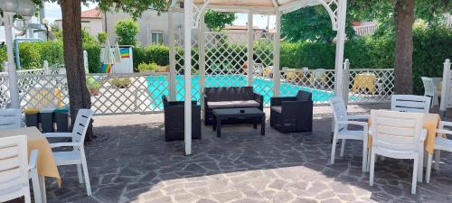 a patio with chairs and a table and a pool at Hotel Garden B&B in Marotta