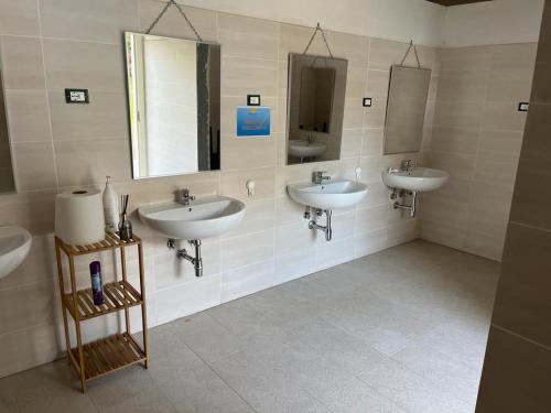 a bathroom with three sinks and two mirrors at Mecca Club in Ischitella