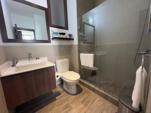 y baño con aseo, lavabo y ducha. en L1C 301 - Boutique apartment in Cayala for 4 guests, en Guatemala