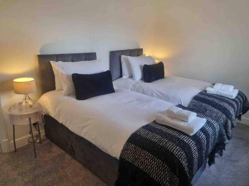 two beds sitting next to each other in a room at 2 Bedroom Cosy Cottage in Rearsby
