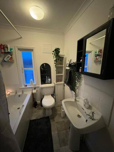 a bathroom with a tub and a toilet and a sink at 2 Bedroom Cosy Cottage in Rearsby