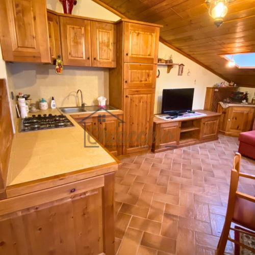 a kitchen with wooden cabinets and a counter top at La Baita sulla Neve - Posto Auto in Rocca Cinquemiglia