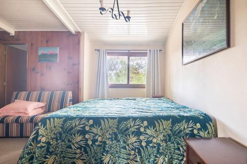 un dormitorio con una cama y una ventana en Casa Papai Noel, en Campos do Jordão