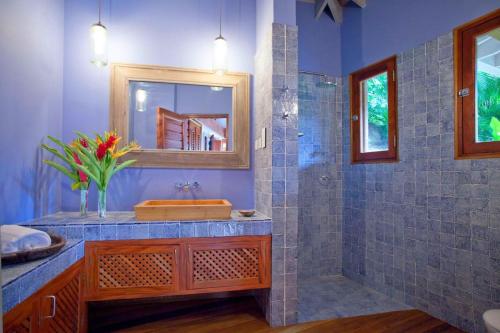 a bathroom with a sink and a shower with a mirror at Amazing 6 BR Ocen View Villa in Marigot Bay in Marigot Bay