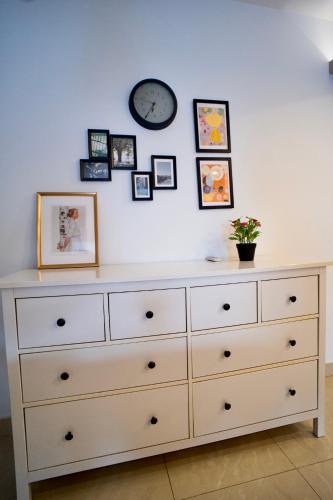 a dresser against a white wall with pictures on it at Mirage residence resort in Cairo