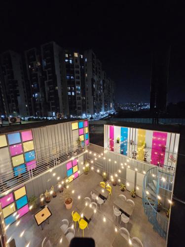 un patio all'ultimo piano con tavoli e sedie di notte di Coliwo Trois - Kharadi a Pune
