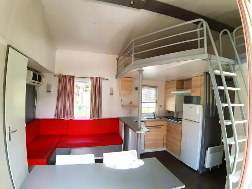 - un salon avec un canapé rouge et des lits superposés dans l'établissement Camping le Rural, à Tibiran-Jaunac