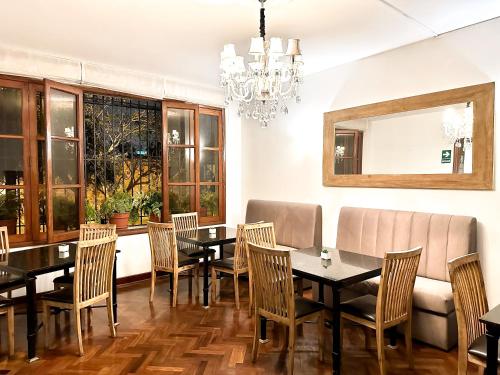 a dining room with a table and chairs and a chandelier at El Golf Hotel Boutique in Lima