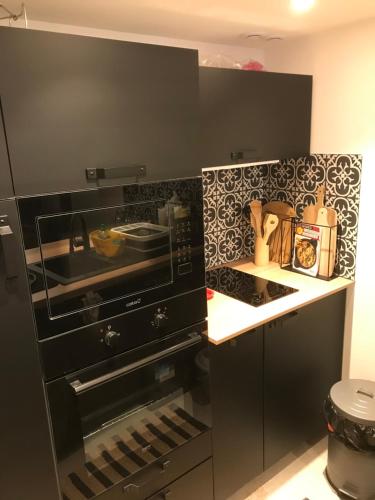 Il comprend une cuisine équipée d'une cuisinière noire et d'un évier. dans l'établissement Une atypique et merveilleuse Petite maison en plein cœur de Nice, à proximité de la mer et des plages, à Nice