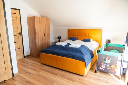 um quarto com uma cama grande e um cobertor azul em Chalety v Pieninách em Cerveny Klástor