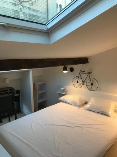 - une chambre avec un lit et un vélo sur le mur dans l'établissement Une atypique et merveilleuse Petite maison en plein cœur de Nice, à proximité de la mer et des plages, à Nice